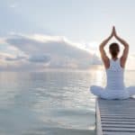 Femme qui pratique sa sadhana quotidienne sur la plage