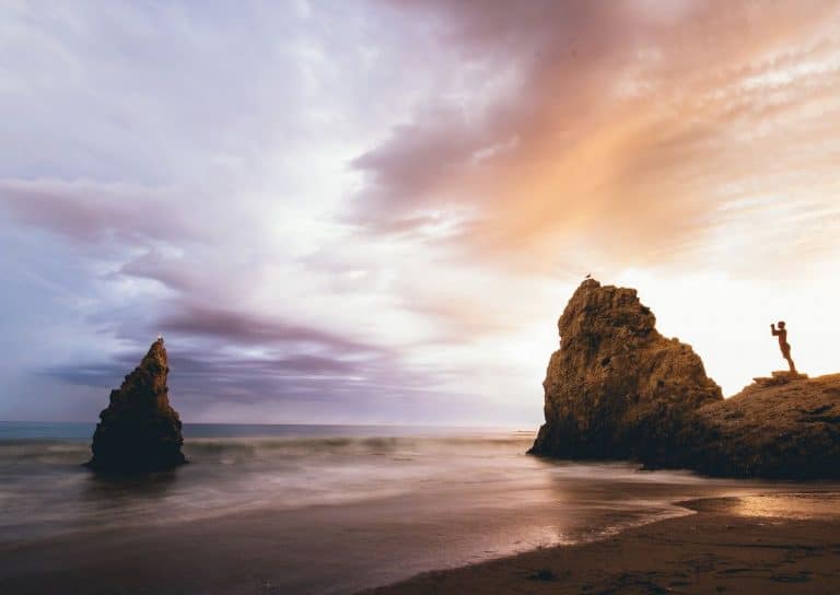 Image de rochers dans la mer entre chien et loup