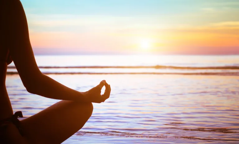 Méditation sur la plage, au coucher du soleil