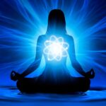 Apprenez à Percevoir L'Aura Une silhouette d'une personne en position du lotus méditant sur un fond bleu vif. Une lumière vive émane de leur poitrine, formant un symbole semblable à un atome avec des lignes d'énergie lumineuses s'étendant vers l'extérieur, créant un sentiment de spiritualité et de paix intérieure comme on pourrait percevoir une aura.