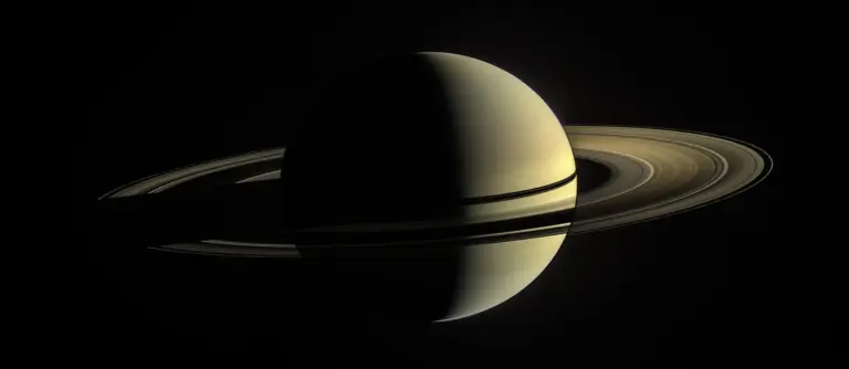 Une image saisissante de Saturne, mettant en valeur ses anneaux proéminents et son hémisphère ombragé. Illuminés par la lumière du soleil, les anneaux affichent des couleurs et des textures variées, tandis que Le Principe Saturne révèle de subtiles bandes atmosphériques. Le fond noir profond et sans étoiles met en valeur la silhouette éthérée de Saturne.