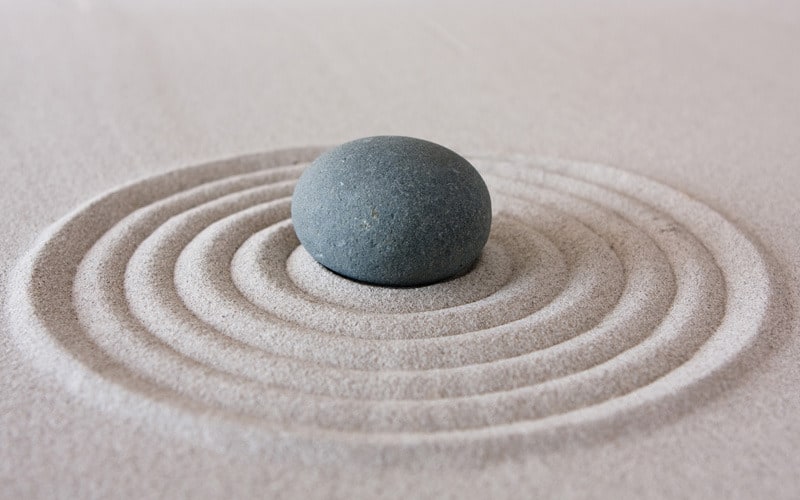 jardin zen, caillou au milieu de cercles dans le sable