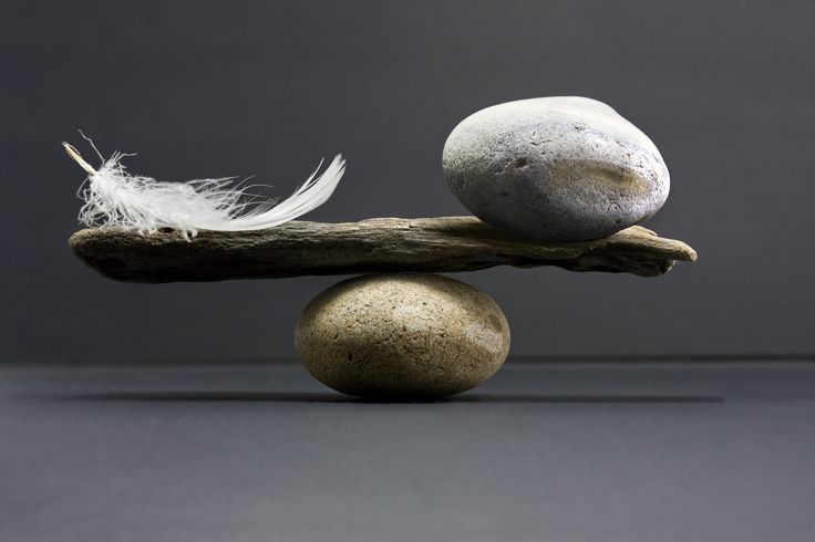 Une plume et une pierre en équilibre sur une balance